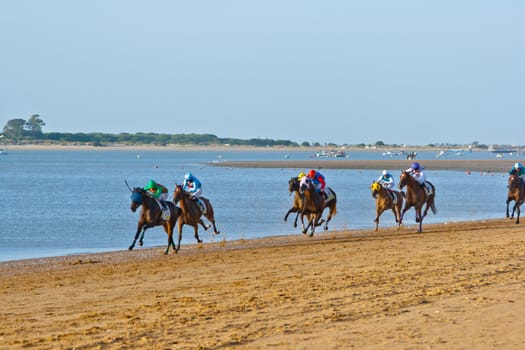 SANLUCAR DE BARRAMEDA, CADIZ, SPAIN - AUGUST 10: Unidentified riders at the start of race horses on Sanlucar de Barrameda beach on August 10, 2011 in Sanlucar de Barrameda, Cadiz, Spain.