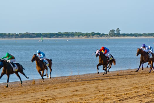SANLUCAR DE BARRAMEDA, CADIZ, SPAIN - AUGUST 10: Unidentified riders at the start of race horses on Sanlucar de Barrameda beach on August 10, 2011 in Sanlucar de Barrameda, Cadiz, Spain.