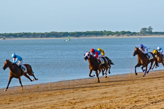 SANLUCAR DE BARRAMEDA, CADIZ, SPAIN - AUGUST 10: Unidentified riders at the start of race horses on Sanlucar de Barrameda beach on August 10, 2011 in Sanlucar de Barrameda, Cadiz, Spain.