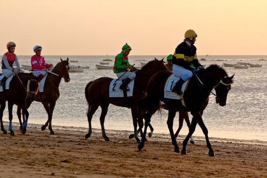SANLUCAR DE BARRAMEDA, CADIZ, SPAIN - AUGUST 10: Unidentified riders at the start of race horses on Sanlucar de Barrameda beach on August 10, 2011 in Sanlucar de Barrameda, Cadiz, Spain.