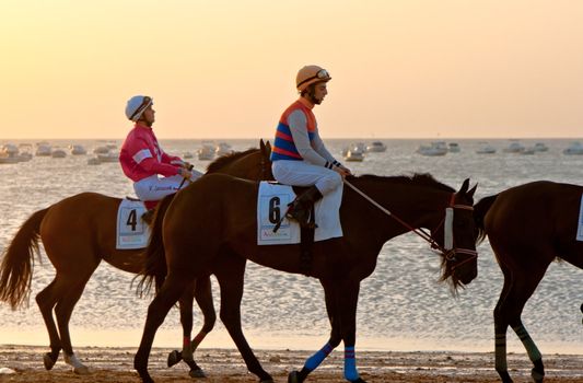 SANLUCAR DE BARRAMEDA, CADIZ, SPAIN - AUGUST 10: Unidentified riders at the start of race horses on Sanlucar de Barrameda beach on August 10, 2011 in Sanlucar de Barrameda, Cadiz, Spain.