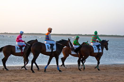 SANLUCAR DE BARRAMEDA, CADIZ, SPAIN - AUGUST 10: Unidentified riders at the start of race horses on Sanlucar de Barrameda beach on August 10, 2011 in Sanlucar de Barrameda, Cadiz, Spain.