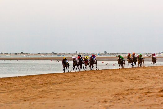 SANLUCAR DE BARRAMEDA, CADIZ, SPAIN - AUGUST 10: Unidentified riders at the start of race horses on Sanlucar de Barrameda beach on August 10, 2011 in Sanlucar de Barrameda, Cadiz, Spain.