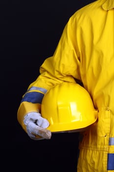 man holding yellow helmet over black background 