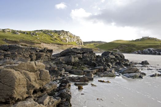 coastal landscape in west scotland. rough stones and green meadow in background