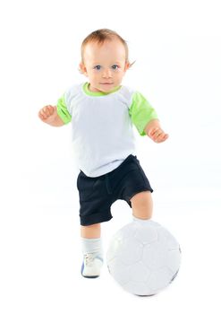 Cute 1 years old boy in sports form with a soccer ball in the studio