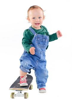 Cute 1 years old boy on a skateboard in the studio