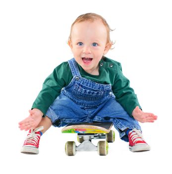 Cute 1 years old boy on a skateboard in the studio