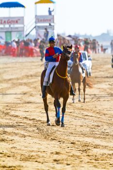 SANLUCAR DE BARRAMEDA, CADIZ, SPAIN - AUGUST 10: Unidentified riders at the start of race horses on Sanlucar de Barrameda beach on August 10, 2011 in Sanlucar de Barrameda, Cadiz, Spain.