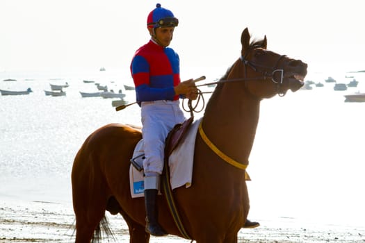 SANLUCAR DE BARRAMEDA, CADIZ, SPAIN - AUGUST 10: Unidentified riders at the start of race horses on Sanlucar de Barrameda beach on August 10, 2011 in Sanlucar de Barrameda, Cadiz, Spain.