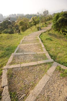 Path on hill in park in modern city in daytime with nobody.