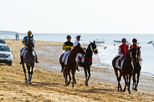 SANLUCAR DE BARRAMEDA, CADIZ, SPAIN - AUGUST 10: Unidentified riders at the start of race horses on Sanlucar de Barrameda beach on August 10, 2011 in Sanlucar de Barrameda, Cadiz, Spain.