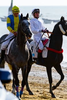 SANLUCAR DE BARRAMEDA, CADIZ, SPAIN - AUGUST 10: Unidentified riders at the start of race horses on Sanlucar de Barrameda beach on August 10, 2011 in Sanlucar de Barrameda, Cadiz, Spain.