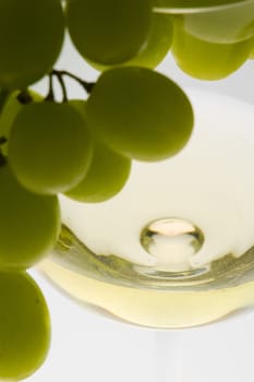 wineglass with white wine and grape