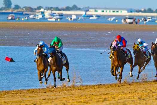 SANLUCAR DE BARRAMEDA, CADIZ, SPAIN - AUGUST 10: Unidentified riders at the start of race horses on Sanlucar de Barrameda beach on August 10, 2011 in Sanlucar de Barrameda, Cadiz, Spain.