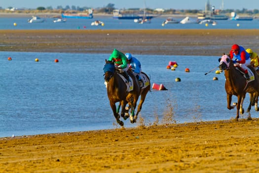 SANLUCAR DE BARRAMEDA, CADIZ, SPAIN - AUGUST 10: Unidentified riders at the start of race horses on Sanlucar de Barrameda beach on August 10, 2011 in Sanlucar de Barrameda, Cadiz, Spain.