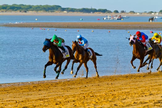 SANLUCAR DE BARRAMEDA, CADIZ, SPAIN - AUGUST 10: Unidentified riders at the start of race horses on Sanlucar de Barrameda beach on August 10, 2011 in Sanlucar de Barrameda, Cadiz, Spain.