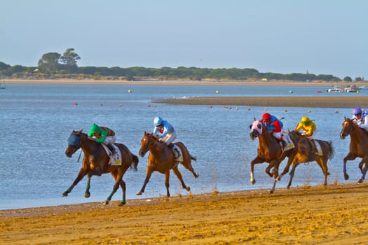 SANLUCAR DE BARRAMEDA, CADIZ, SPAIN - AUGUST 10: Unidentified riders at the start of race horses on Sanlucar de Barrameda beach on August 10, 2011 in Sanlucar de Barrameda, Cadiz, Spain.