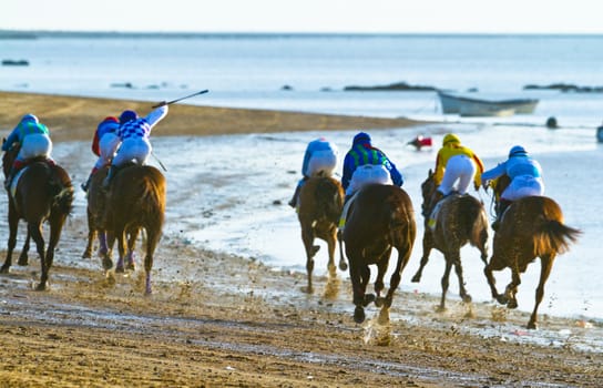 SANLUCAR DE BARRAMEDA, CADIZ, SPAIN - AUGUST 10: Unidentified riders at the start of race horses on Sanlucar de Barrameda beach on August 10, 2011 in Sanlucar de Barrameda, Cadiz, Spain.