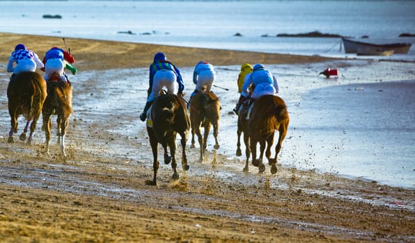SANLUCAR DE BARRAMEDA, CADIZ, SPAIN - AUGUST 10: Unidentified riders at the start of race horses on Sanlucar de Barrameda beach on August 10, 2011 in Sanlucar de Barrameda, Cadiz, Spain.