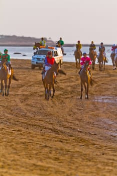 SANLUCAR DE BARRAMEDA, CADIZ, SPAIN - AUGUST 10: Unidentified riders at the start of race horses on Sanlucar de Barrameda beach on August 10, 2011 in Sanlucar de Barrameda, Cadiz, Spain.