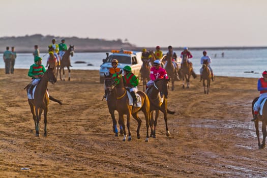 SANLUCAR DE BARRAMEDA, CADIZ, SPAIN - AUGUST 10: Unidentified riders at the start of race horses on Sanlucar de Barrameda beach on August 10, 2011 in Sanlucar de Barrameda, Cadiz, Spain.