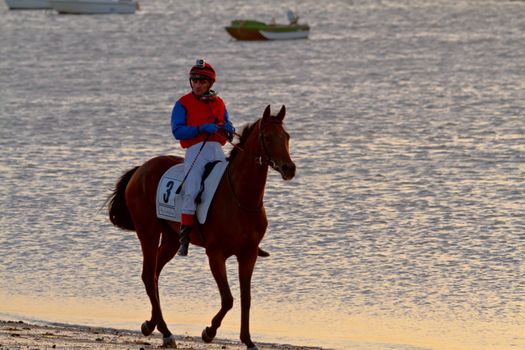 SANLUCAR DE BARRAMEDA, CADIZ, SPAIN - AUGUST 10: Unidentified riders at the start of race horses on Sanlucar de Barrameda beach on August 10, 2011 in Sanlucar de Barrameda, Cadiz, Spain.