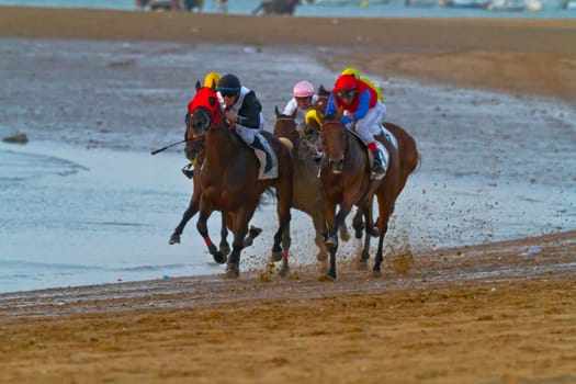 SANLUCAR DE BARRAMEDA, CADIZ, SPAIN - AUGUST 10: Unidentified riders at the start of race horses on Sanlucar de Barrameda beach on August 10, 2011 in Sanlucar de Barrameda, Cadiz, Spain.