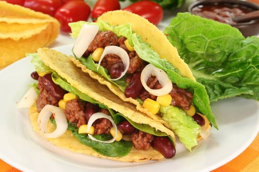 Taco shells filled with ground beef, kidney beans and corn