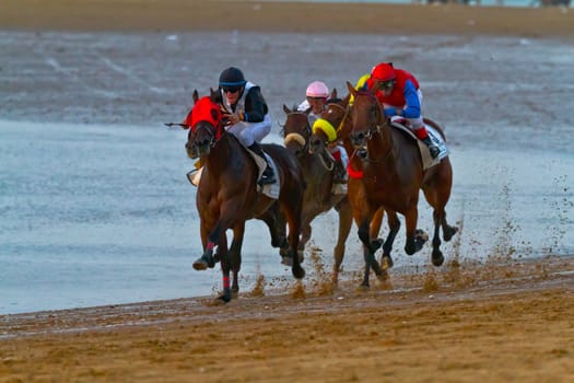 SANLUCAR DE BARRAMEDA, CADIZ, SPAIN - AUGUST 10: Unidentified riders at the start of race horses on Sanlucar de Barrameda beach on August 10, 2011 in Sanlucar de Barrameda, Cadiz, Spain.