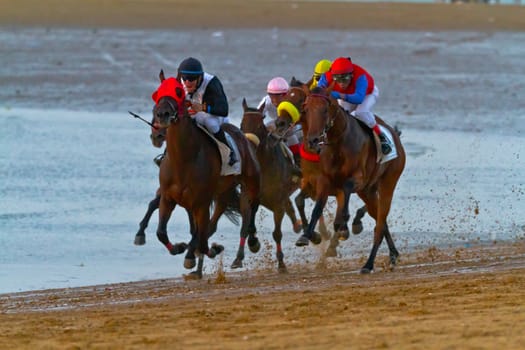 SANLUCAR DE BARRAMEDA, CADIZ, SPAIN - AUGUST 10: Unidentified riders at the start of race horses on Sanlucar de Barrameda beach on August 10, 2011 in Sanlucar de Barrameda, Cadiz, Spain.
