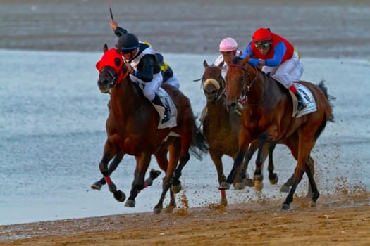 SANLUCAR DE BARRAMEDA, CADIZ, SPAIN - AUGUST 10: Unidentified riders at the start of race horses on Sanlucar de Barrameda beach on August 10, 2011 in Sanlucar de Barrameda, Cadiz, Spain.
