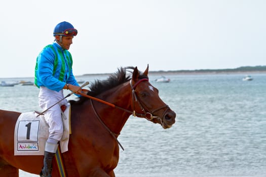 SANLUCAR DE BARRAMEDA, CADIZ, SPAIN - AUGUST 11: Unidentified rider at the start of race horses on Sanlucar de Barrameda beach on August 11, 2011 in Sanlucar de Barrameda, Cadiz, Spain.