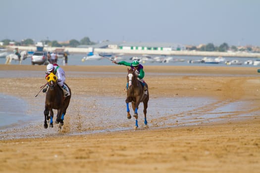 SANLUCAR DE BARRAMEDA, CADIZ, SPAIN - AUGUST 11: Unidentified rider at the start of race horses on Sanlucar de Barrameda beach on August 11, 2011 in Sanlucar de Barrameda, Cadiz, Spain.