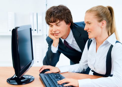 Smiling and young business people working together on the computer.Screen has a clipping path.