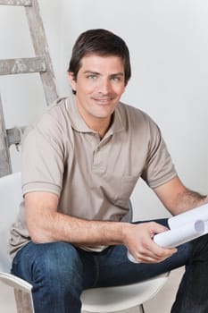 Portrait of young handsome man holding with blueprint