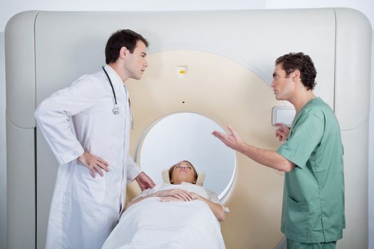 A doctor and technician discussing a CT scan