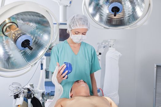 Doctor applying oxygen mask on patient before operation