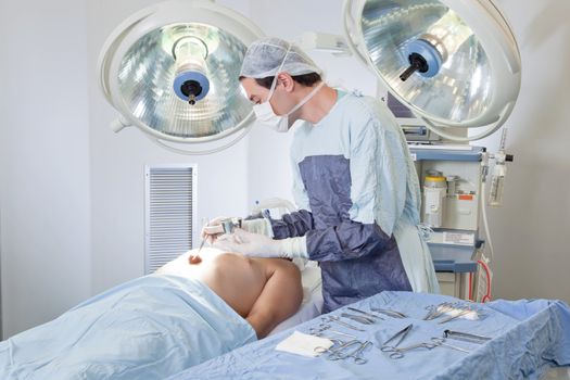 Doctor performing operation on patient in operating room