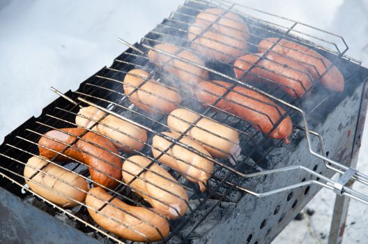 grilled sausages on grill, with smoke above it