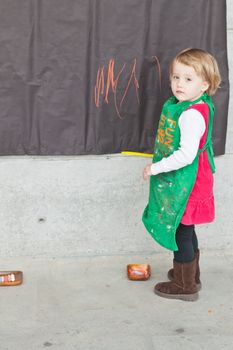 Cute little baby girl having fun painting at art class