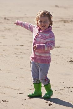 Cute little baby girl having fun on a beach