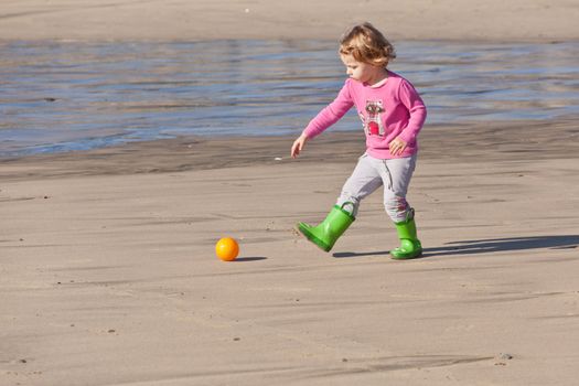 Cute little baby girl having fun on a beach