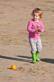 Cute little baby girl having fun on a beach