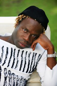 Portrait of young sad African descent man in white t-shirt on green background. Indonesia