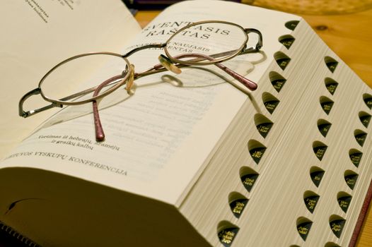 Bible book in the Swedish languageand glasses taken as macro