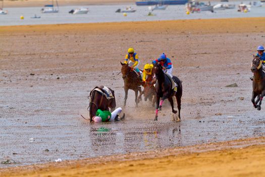 SANLUCAR DE BARRAMEDA, CADIZ, SPAIN - AUGUST 11: Unidentified riders race horses on Sanlucar de Barrameda beach on August 11, 2011 in Sanlucar de Barrameda, Cadiz, Spain.