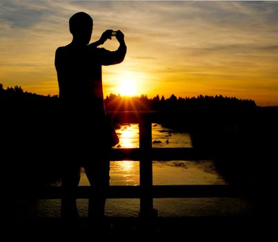 A person on a bridge making a photo