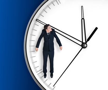 Businessman hangs on an arrow of clock, isolated on blue background