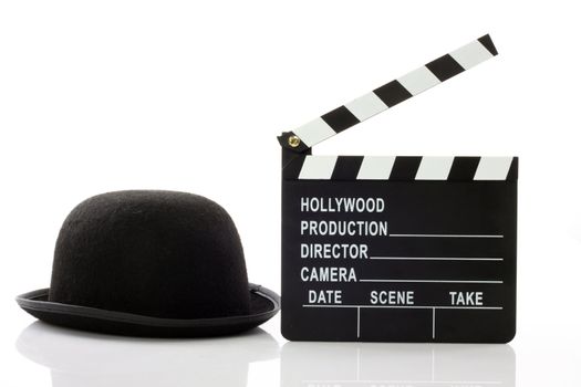Bowler hat and movie clapper over white